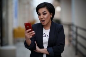 Mujer sorprendida ante celular en mano